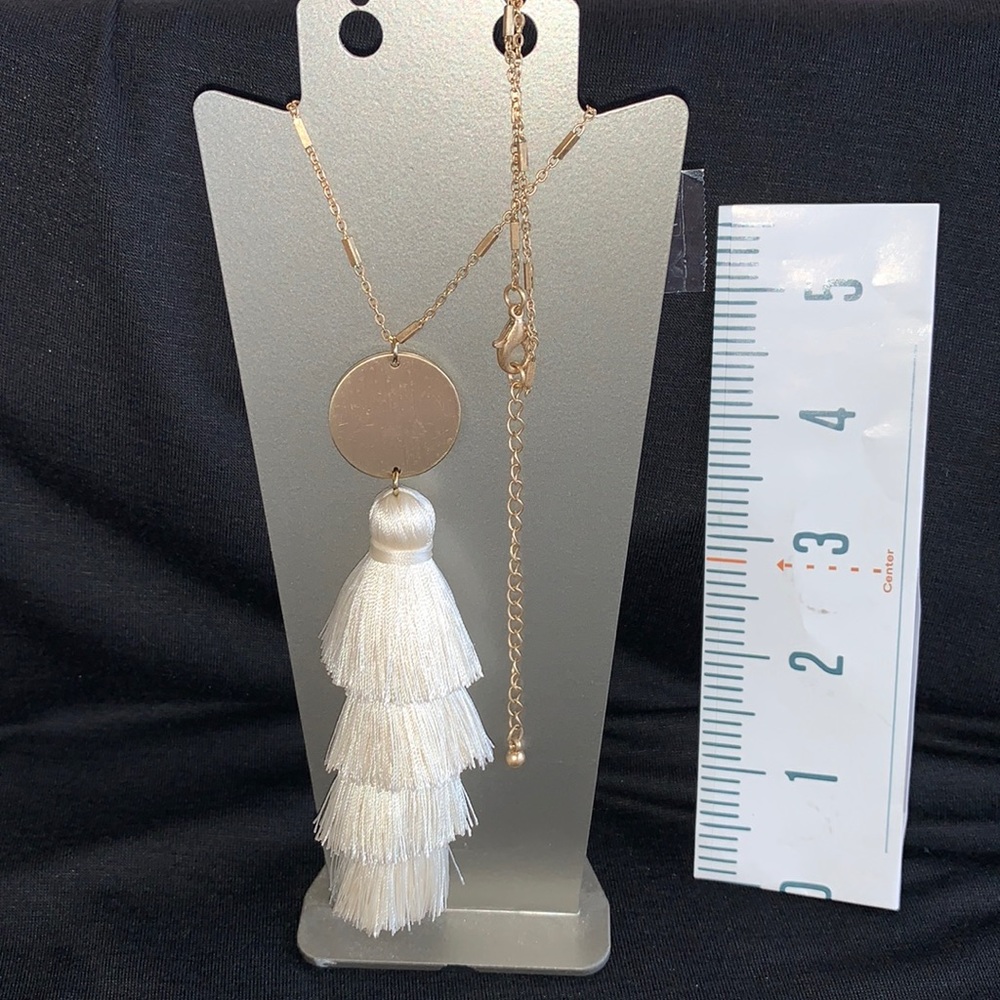 One 30” + goldtone necklace, cream colored tassel with circle medallion, new.